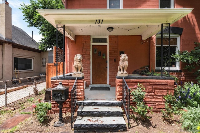 131 Fox St, Denver, CO 80223 - doorway to property with brick siding and a porch