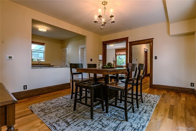 131 Fox St, Denver, CO 80223 - dining space featuring a chandelier, wood finished floors, and plenty of natural light