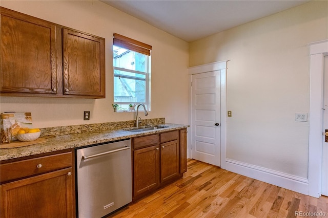 131 Fox St, Denver, CO 80223 - kitchen with dishwasher, light wood-style flooring, brown cabinets, and light stone counters