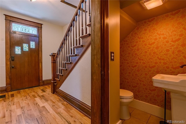 131 Fox St, Denver, CO 80223 - foyer with stairs, wallpapered walls, and wood finished floors