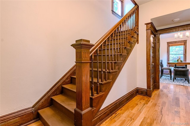 131 Fox St, Denver, CO 80223 - stairway with wood finished floors and a chandelier