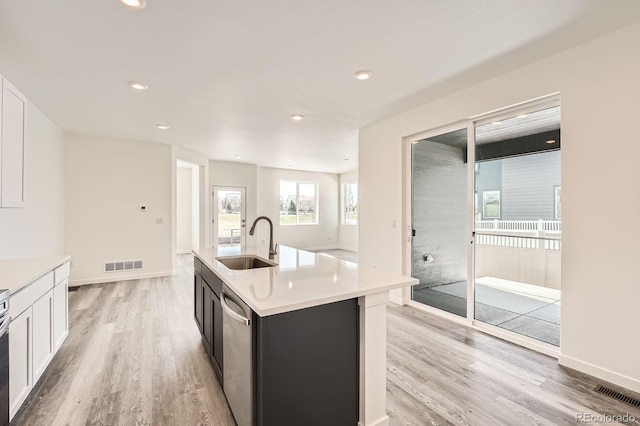 1290 S Algonquian St, Aurora, CO 80018 - kitchen featuring a sink, light wood-type flooring, stainless steel dishwasher, light countertops, and recessed lighting