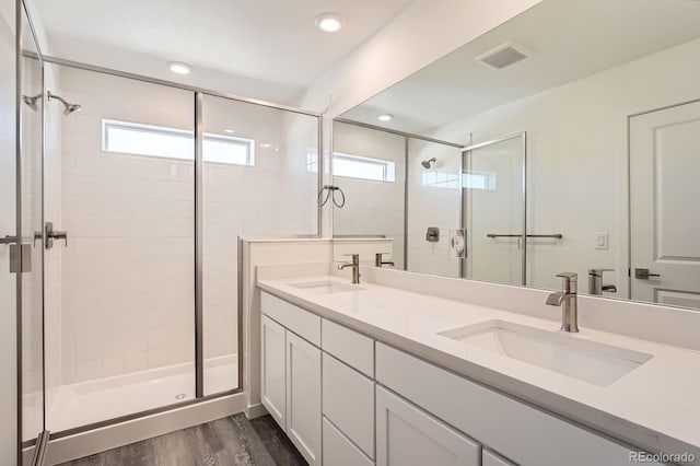 1290 S Algonquian St, Aurora, CO 80018 - full bathroom featuring a stall shower, wood finished floors, double vanity, and recessed lighting