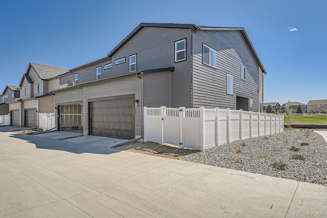 1290 S Algonquian St, Aurora, CO 80018 - view of side of property featuring a garage, fence, and concrete driveway