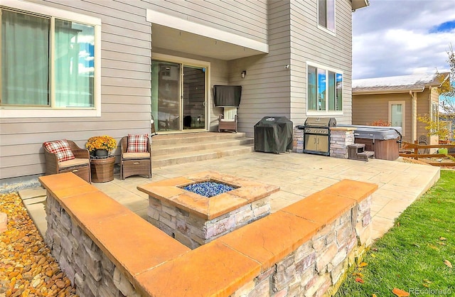 view of patio featuring a hot tub, area for grilling, and an outdoor fire pit