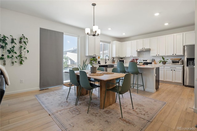 6099 N Netherland Ct, Aurora, CO 80019 - dining room featuring light wood finished floors, a chandelier, recessed lighting, and baseboards