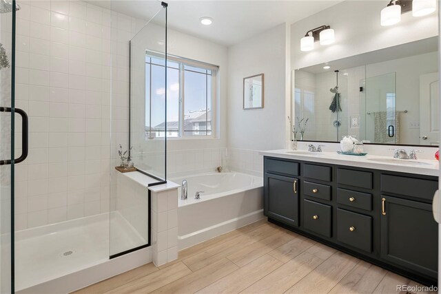 6099 N Netherland Ct, Aurora, CO 80019 - full bath with a stall shower, wood finished floors, double vanity, and a garden tub
