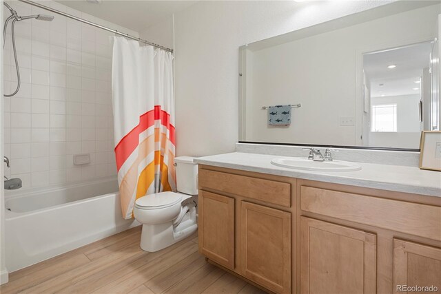6099 N Netherland Ct, Aurora, CO 80019 - bathroom featuring toilet, vanity, wood finished floors, and shower / bath combination with curtain