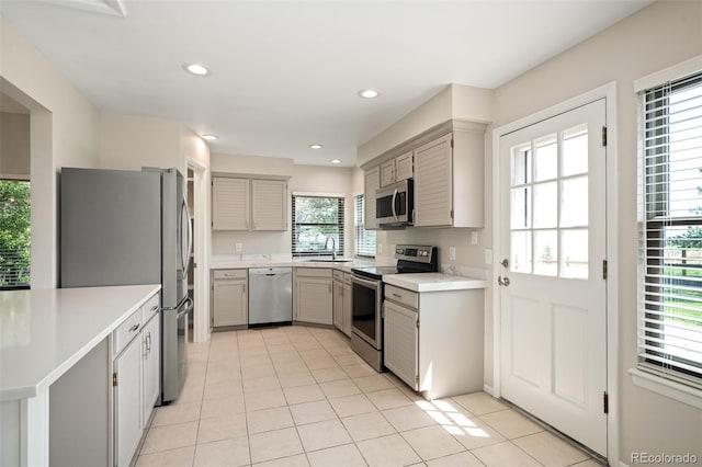 18 Brixham Ct, Castle Pines, CO 80108 - kitchen with stainless steel appliances, a sink, light tile patterned floors, light countertops, and gray cabinets