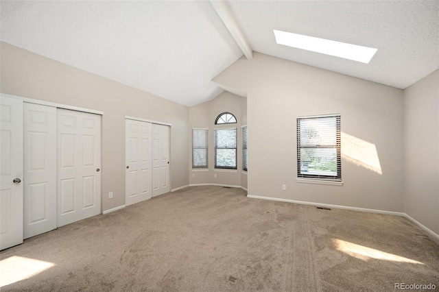18 Brixham Ct, Castle Pines, CO 80108 - unfurnished bedroom featuring a skylight, multiple closets, beam ceiling, carpet flooring, and high vaulted ceiling