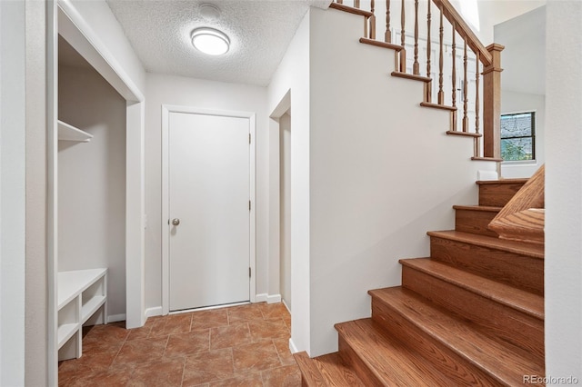 18 Brixham Ct, Castle Pines, CO 80108 - staircase featuring a textured ceiling and baseboards