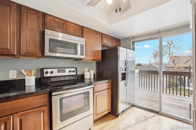 kitchen with light wood-style floors, a ceiling fan, appliances with stainless steel finishes, and brown cabinets