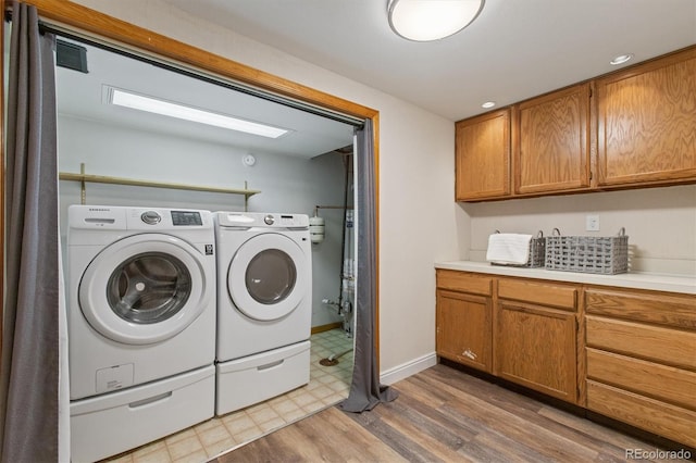 laundry room featuring laundry area, visible vents, wood finished floors, baseboards, and separate washer and dryer