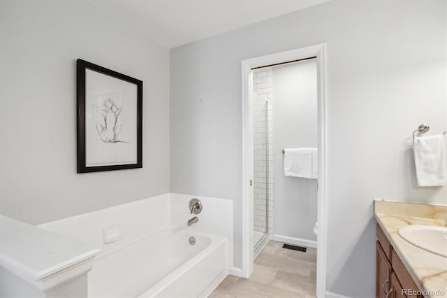 bathroom featuring a bath, visible vents, a stall shower, vanity, and baseboards