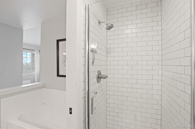bathroom featuring a garden tub, a stall shower, and toilet