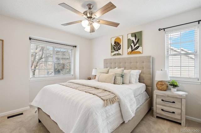 bedroom with baseboards, visible vents, a ceiling fan, and light colored carpet