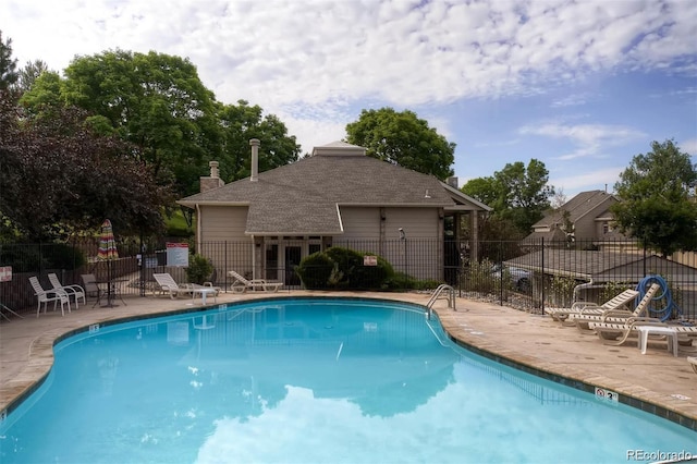 community pool featuring fence and a patio area
