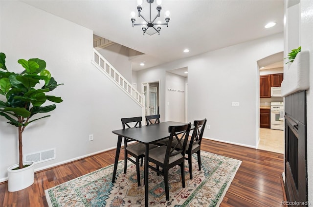 dining room with an inviting chandelier and dark hardwood / wood-style flooring