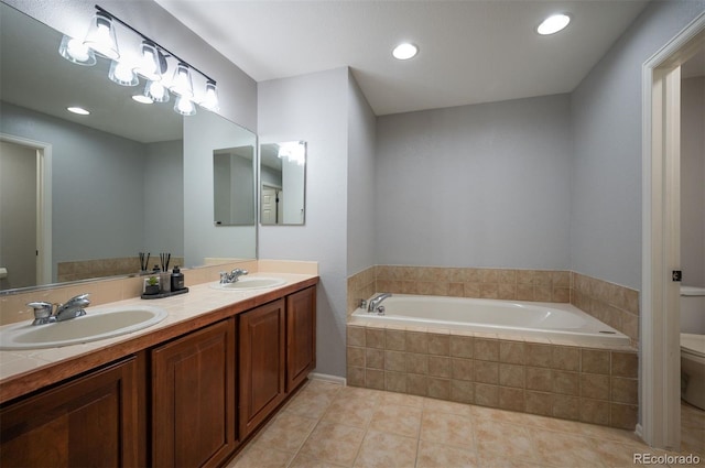 bathroom with vanity, tiled bath, tile patterned floors, and toilet