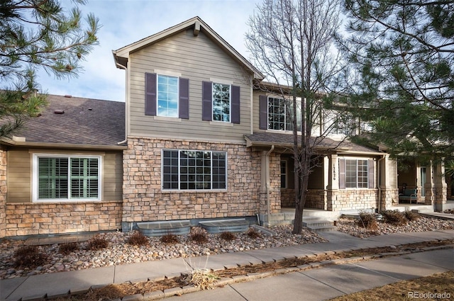 12826 W Brittany Dr, Littleton, CO 80127 - view of front of home featuring stone siding, a porch, and a shingled roof