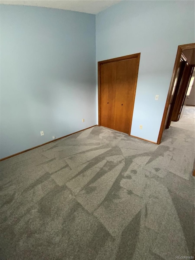 unfurnished bedroom with light colored carpet and a closet