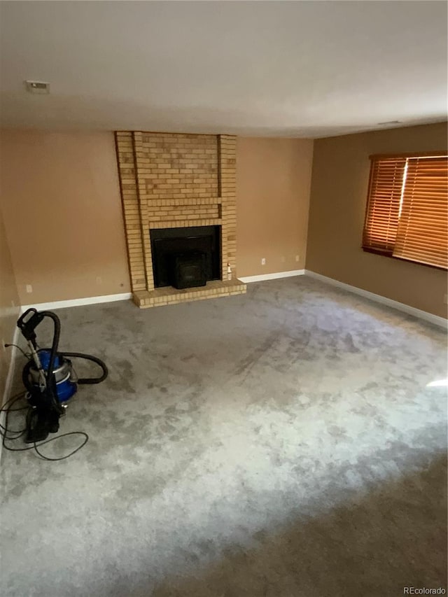 unfurnished living room with a fireplace and carpet flooring