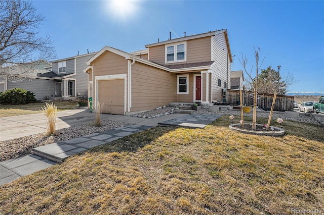 traditional home with concrete driveway, an attached garage, fence, and a front yard