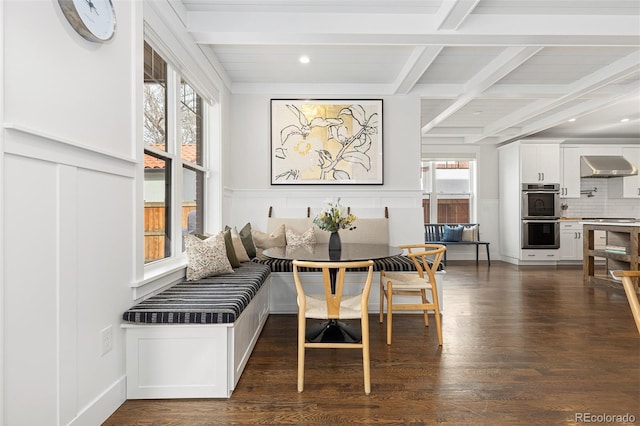 dining space featuring breakfast area, plenty of natural light, beam ceiling, and dark wood-type flooring