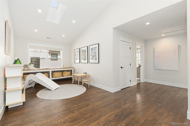 interior space featuring vaulted ceiling with skylight and dark hardwood / wood-style flooring