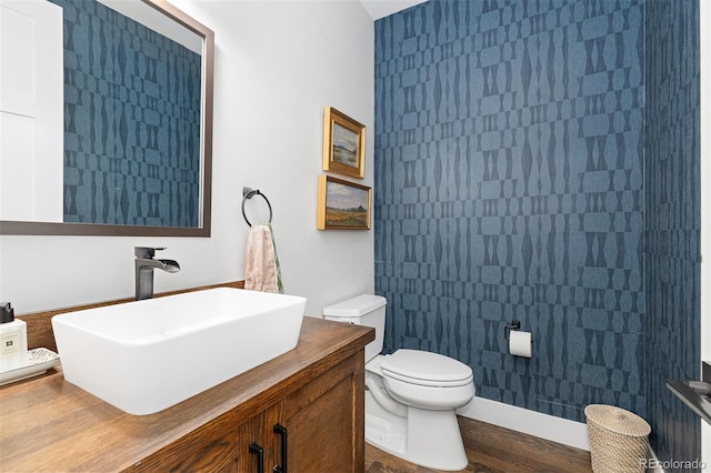 bathroom with vanity, toilet, and hardwood / wood-style floors