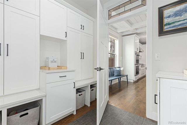 mudroom with beamed ceiling and dark hardwood / wood-style flooring