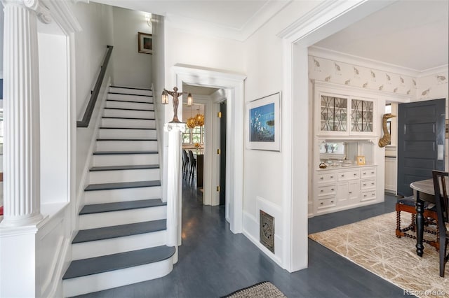 stairs featuring crown molding, decorative columns, and hardwood / wood-style flooring