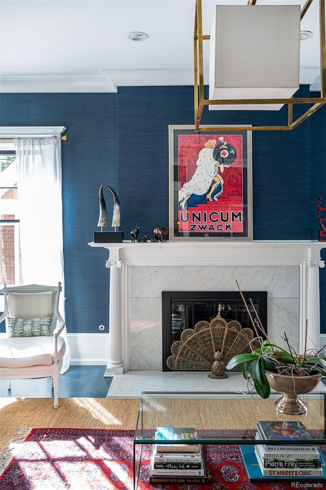 living room with ornamental molding and a high end fireplace