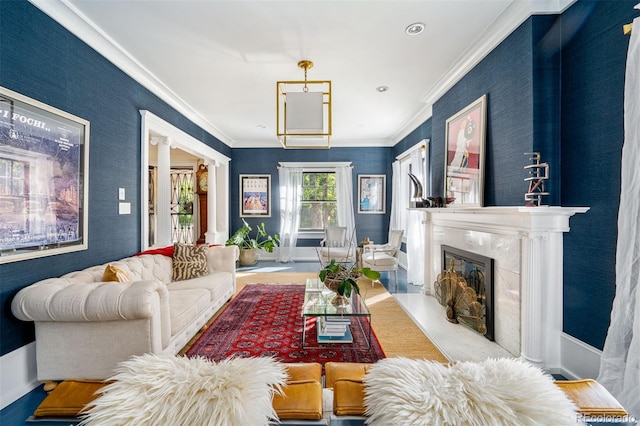 living room with crown molding, a fireplace, and ornate columns