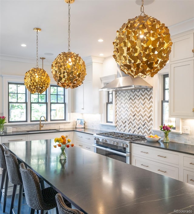 kitchen with stainless steel stove, white cabinets, a breakfast bar area, and tasteful backsplash