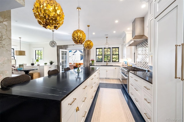 kitchen featuring white cabinets, high end stainless steel range oven, plenty of natural light, and a spacious island