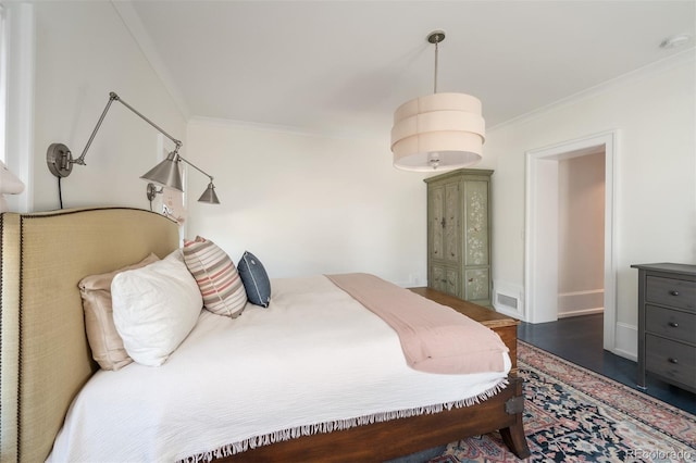 bedroom featuring crown molding and dark hardwood / wood-style flooring