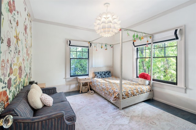 bedroom with an inviting chandelier, ornamental molding, and multiple windows