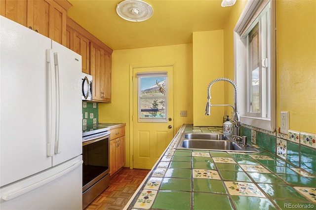 301 Lagoon Ln, Silverthorne, CO 80498 - kitchen with appliances with stainless steel finishes, tile counters, a sink, and brown cabinetry