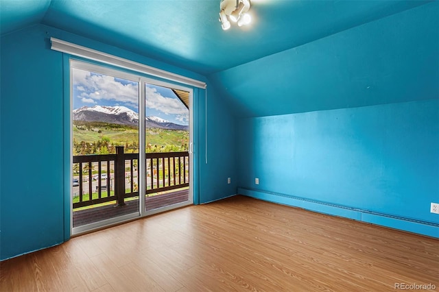 301 Lagoon Ln, Silverthorne, CO 80498 - additional living space featuring vaulted ceiling, baseboard heating, a mountain view, and wood finished floors