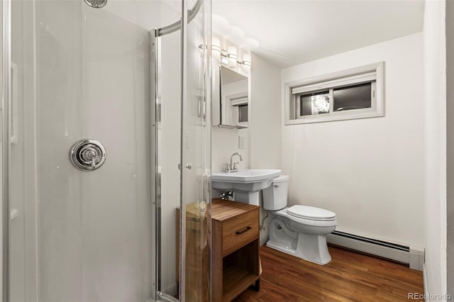 301 Lagoon Ln, Silverthorne, CO 80498 - bathroom featuring a baseboard heating unit, a stall shower, toilet, wood finished floors, and a sink