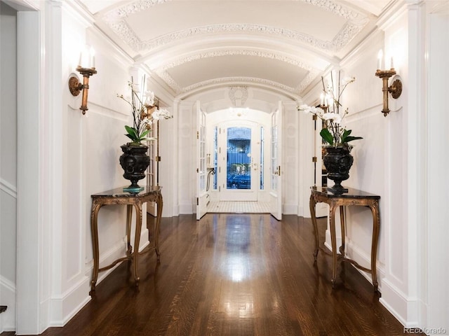 foyer with dark wood-type flooring and vaulted ceiling