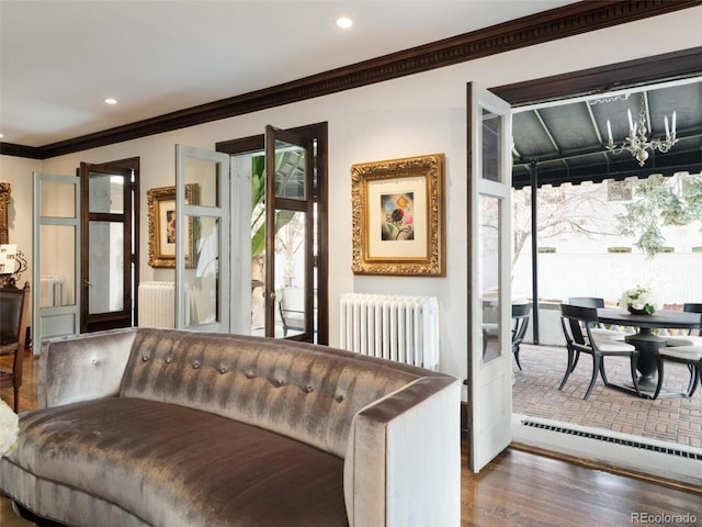 living room featuring a baseboard heating unit, radiator heating unit, ornamental molding, and dark hardwood / wood-style floors