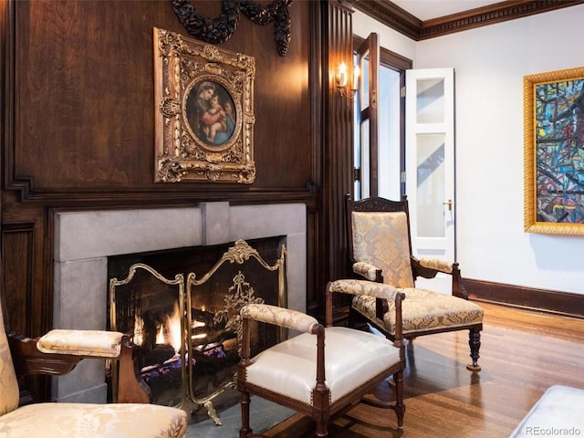 living area with crown molding and hardwood / wood-style flooring