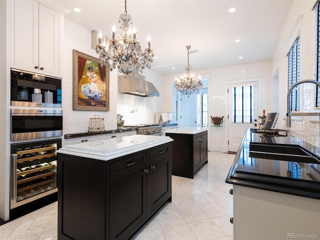 kitchen with hanging light fixtures, a kitchen island, sink, and wine cooler