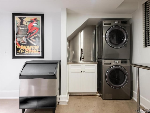 laundry room featuring stacked washer / dryer, sink, and cabinets