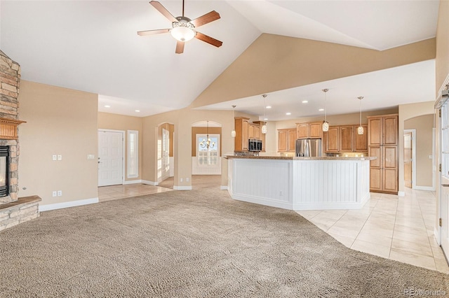 unfurnished living room with a fireplace, light colored carpet, high vaulted ceiling, and ceiling fan