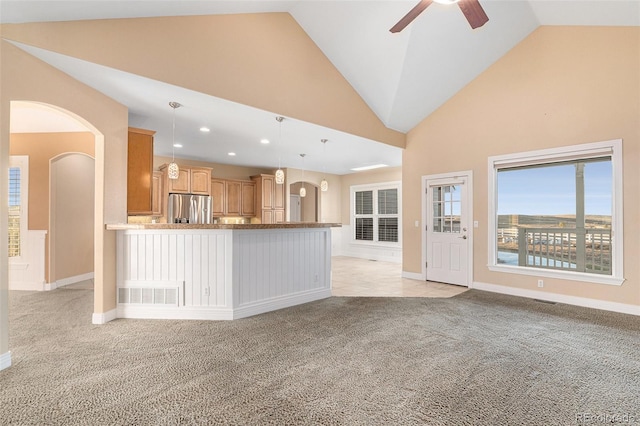 unfurnished living room with light carpet, vaulted ceiling, and ceiling fan