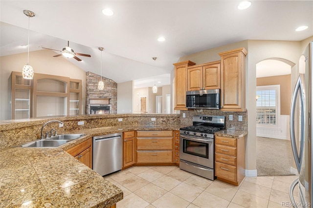 kitchen featuring pendant lighting, sink, ceiling fan, decorative backsplash, and stainless steel appliances