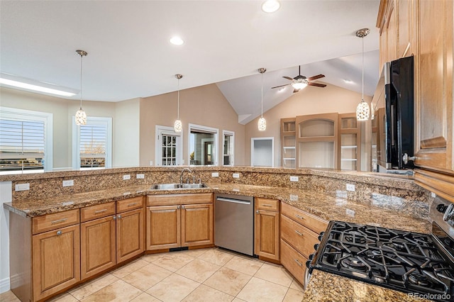 kitchen with dishwasher, dark stone counters, sink, ceiling fan, and gas range oven